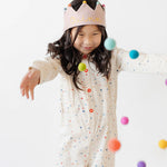 girl wearing polka dot romper with pink birthday crown