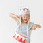 girl wearing pink birthday crown and playing drum